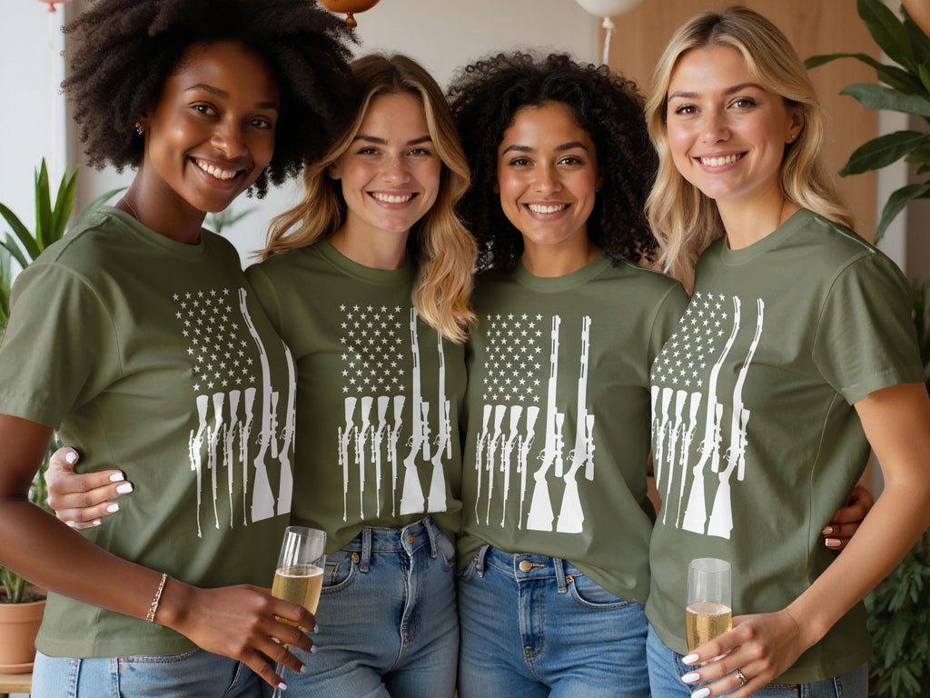 Four women in olive green t-shirts with white rifle flag design and blue jeans.