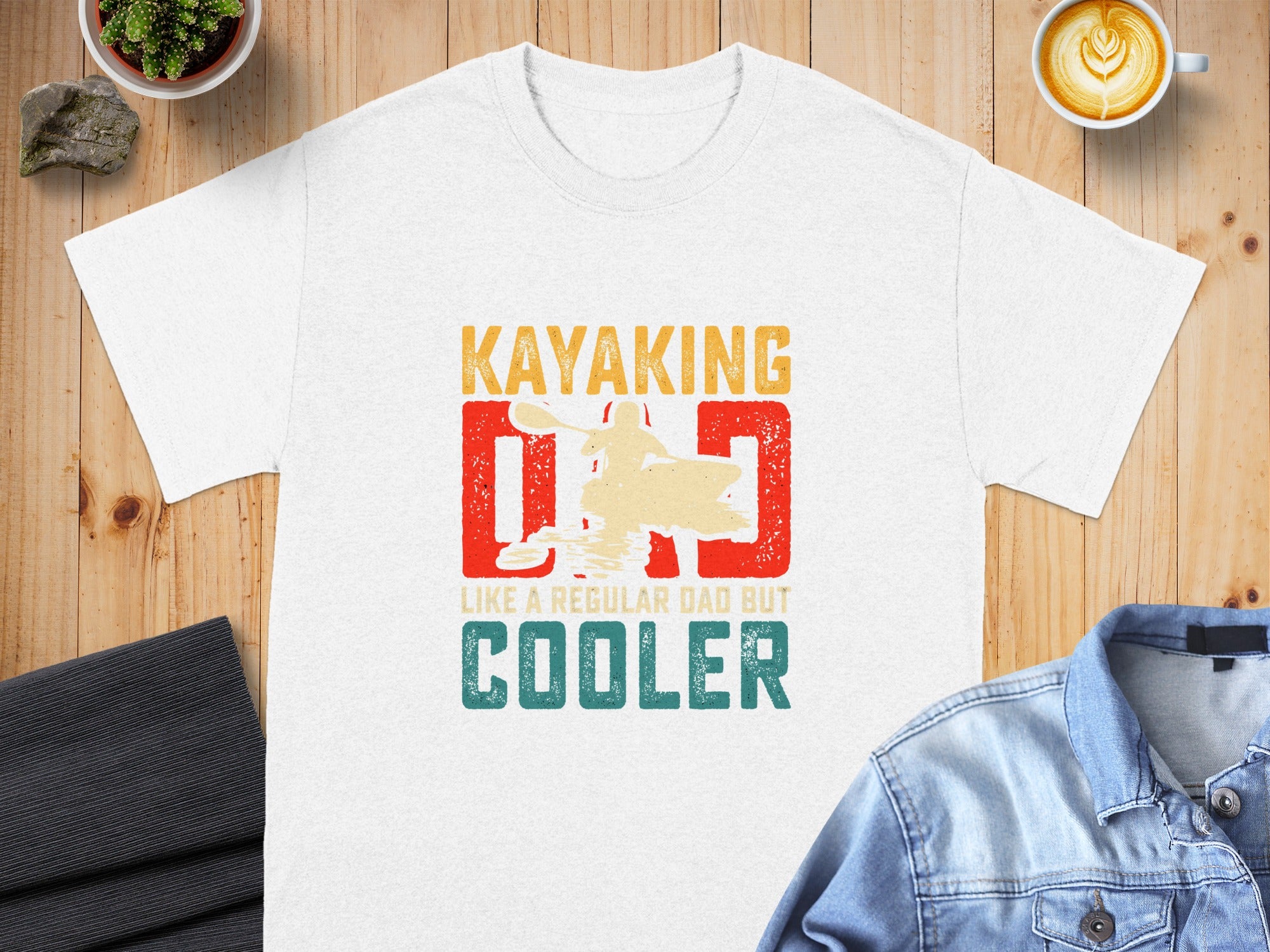 White t-shirt with "Kayaking Dad cooler" text and kayak graphic.