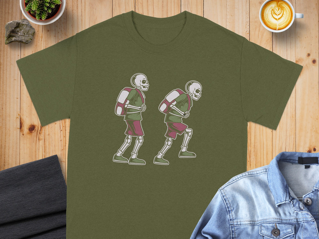 Green t-shirt featuring a graphic of two skeletons with backpacks walking.