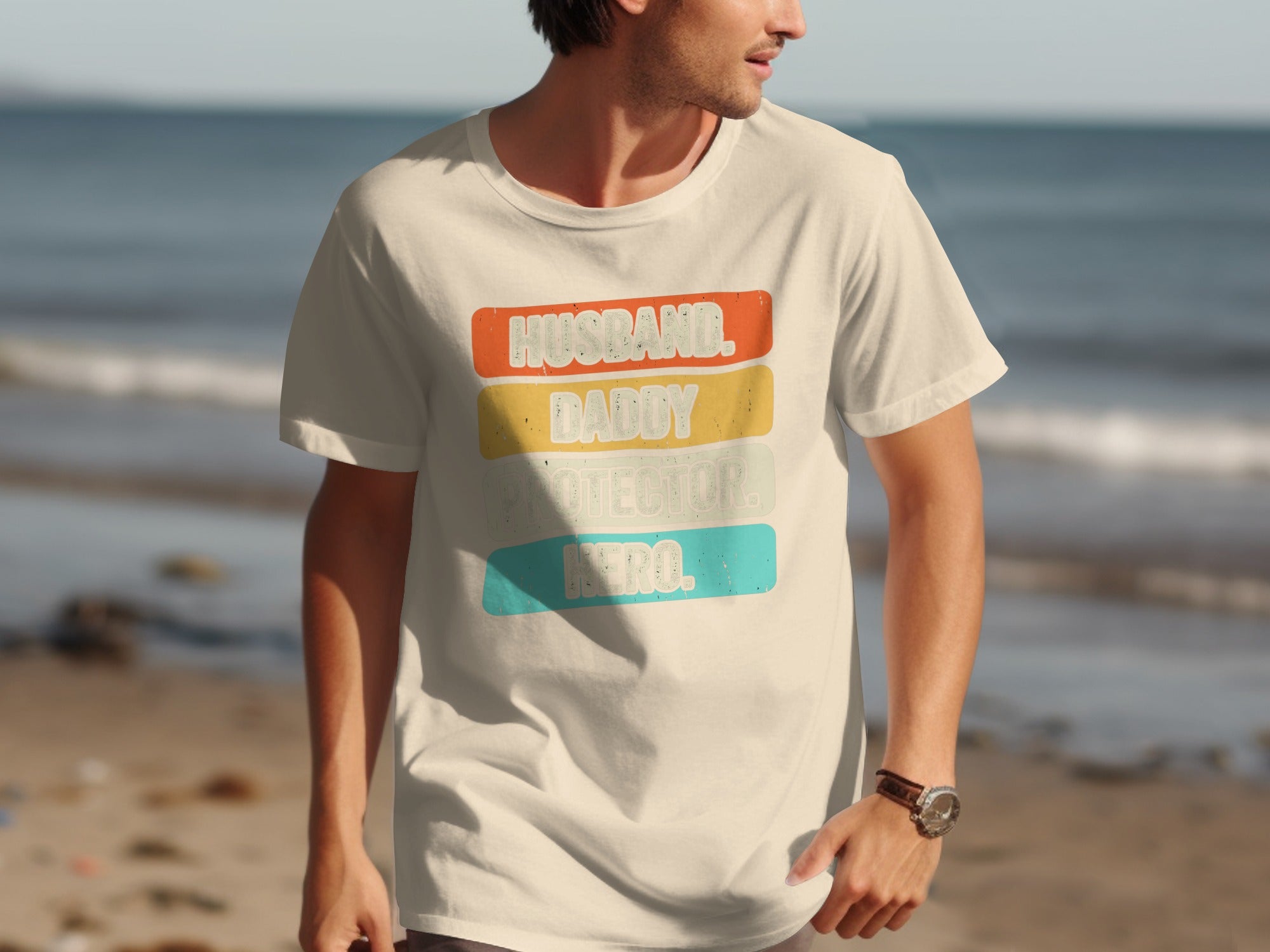 Cream t-shirt with "HUSBAND. DADDY. PROTECTOR. HERO." text in colored blocks.