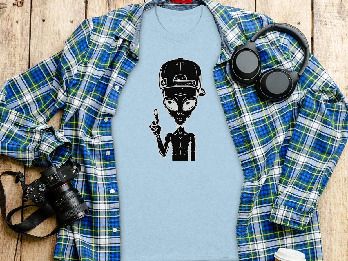 Light blue t-shirt with black alien graphic wearing a baseball cap and holding up one finger.
