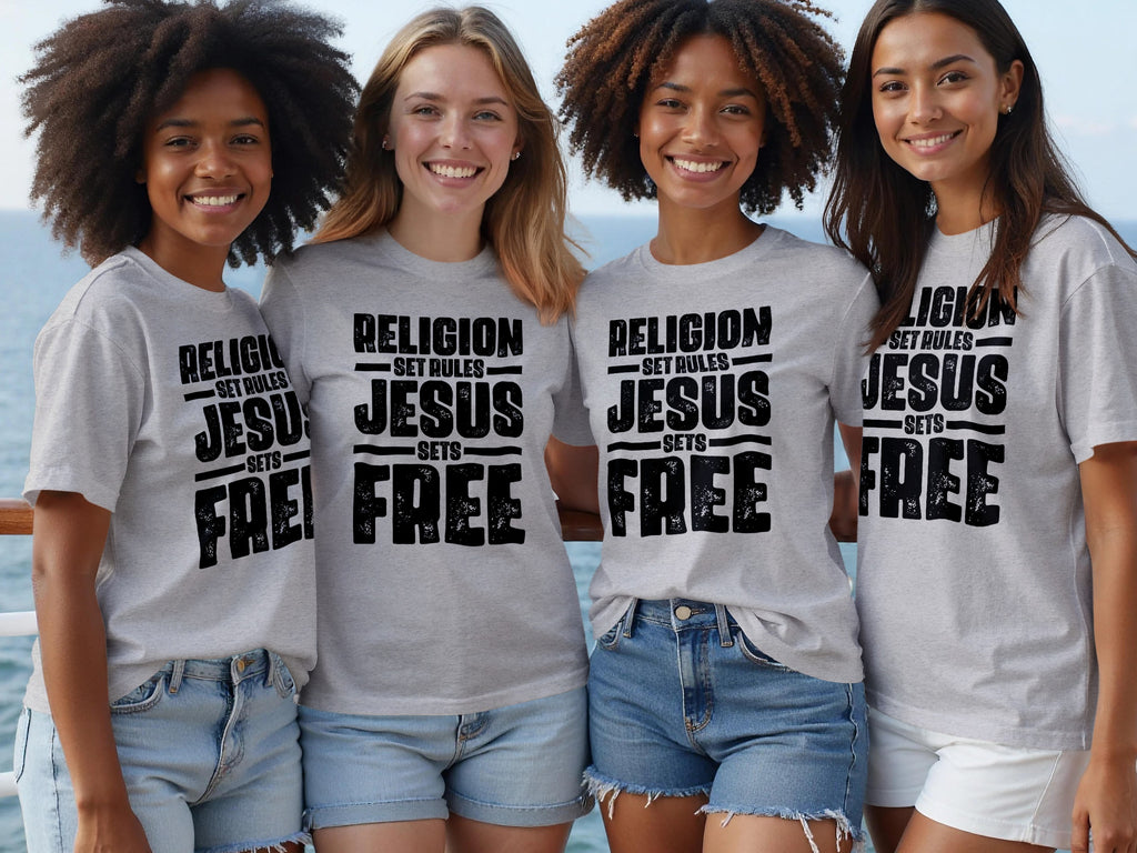 Four smiling women wear grey t-shirts with black text reading "RELIGION SET RULES JESUS SETS FREE".