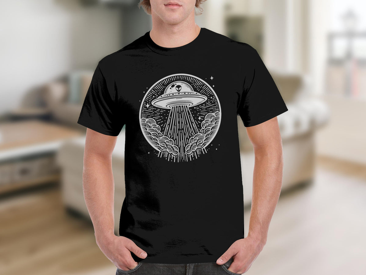 Black t-shirt with a circular alien and UFO design with beams and clouds.