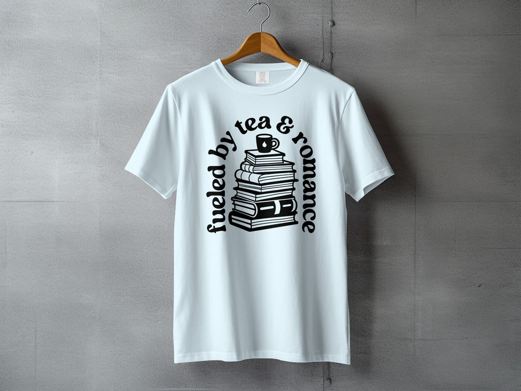 Light blue t-shirt with black text and illustration of stacked books with a tea cup.