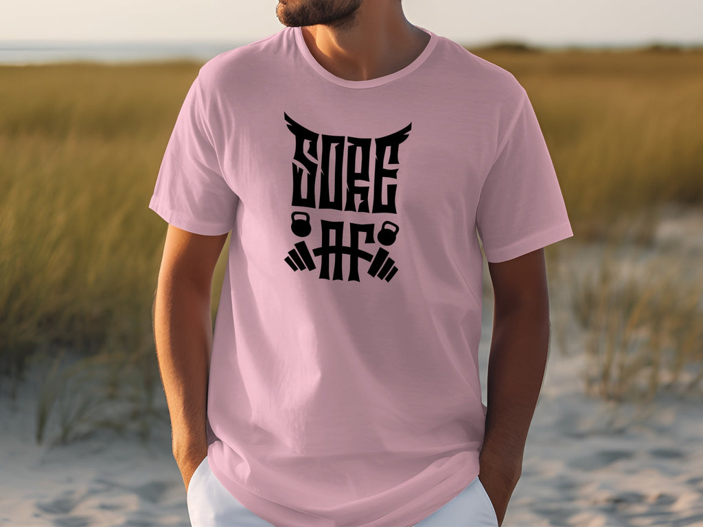 Pink t-shirt with black text "SORE AF" and kettlebells graphics.