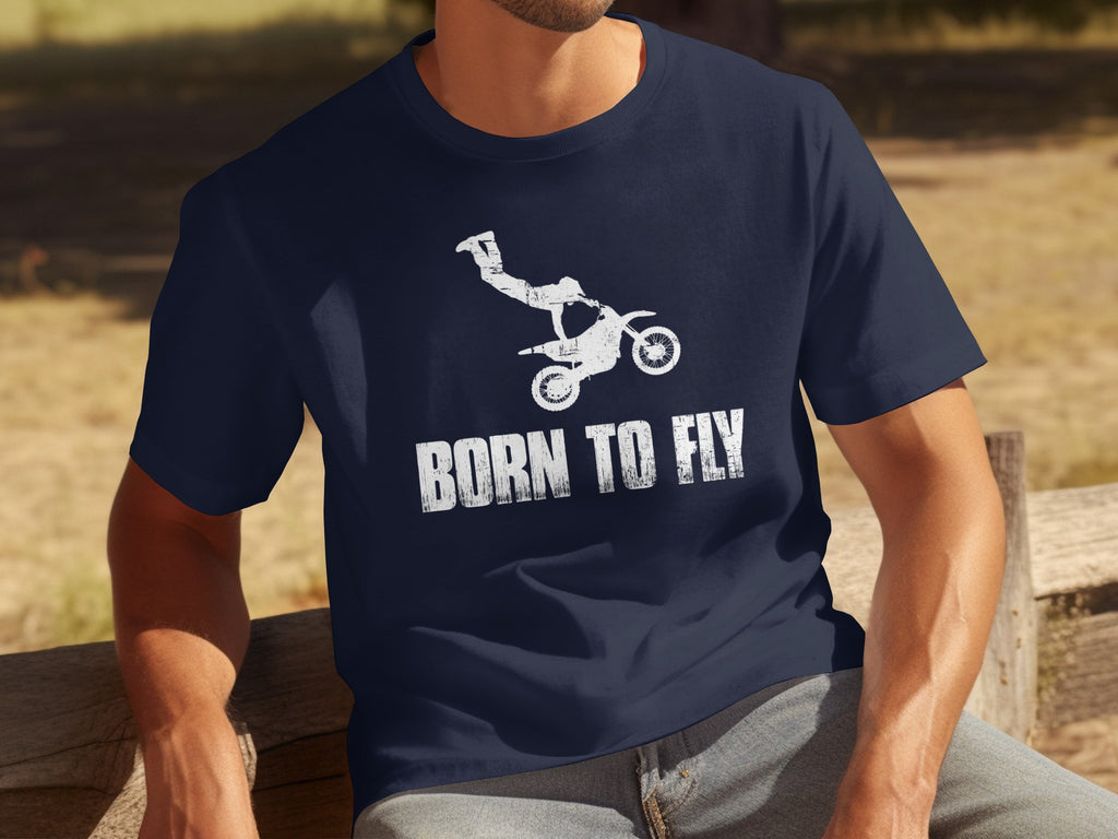 Navy t-shirt with white distressed graphic of a motocross rider performing a trick and text "BORN TO FLY".