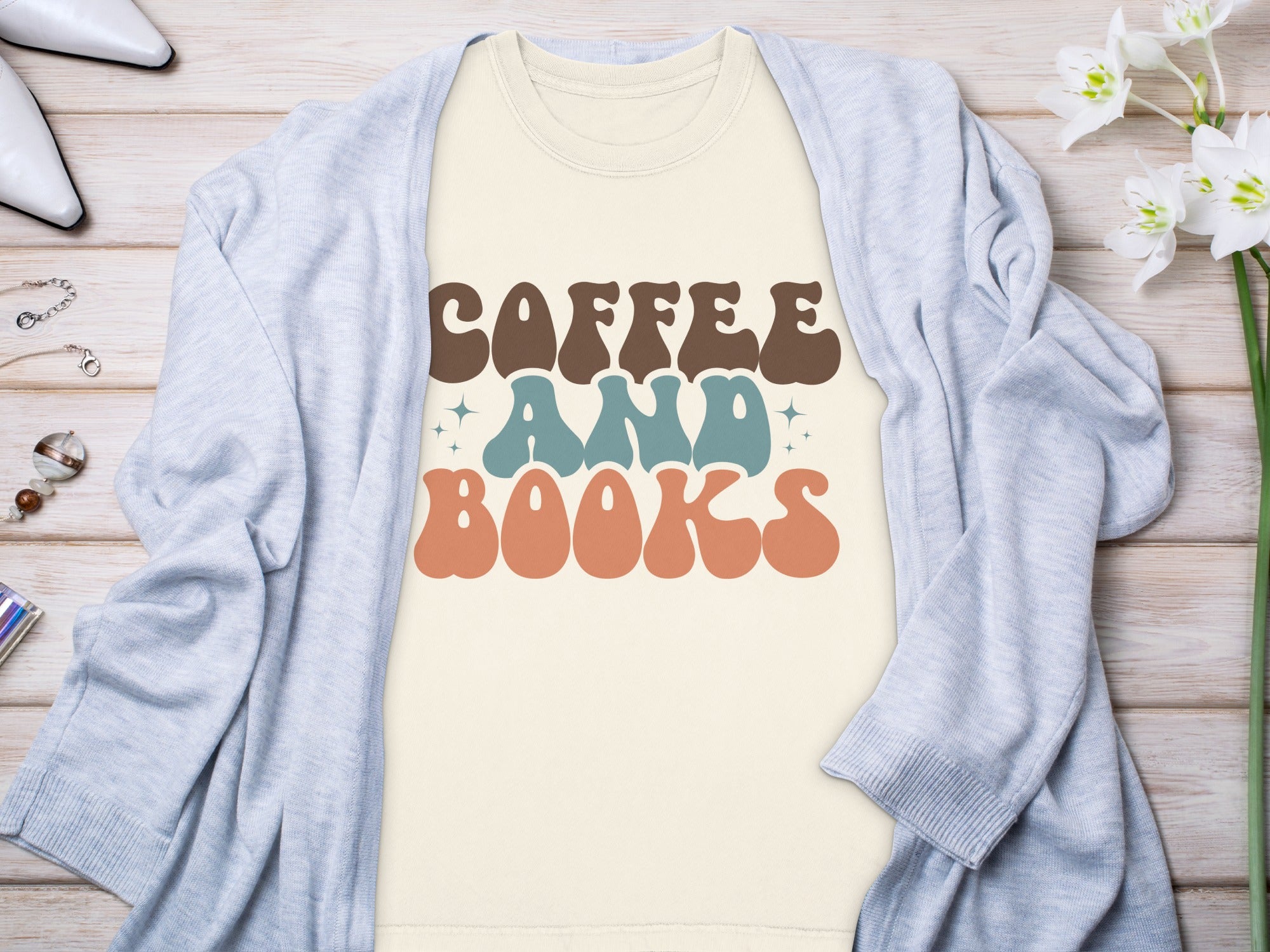 Cream t-shirt with brown, blue, and orange text reading "COFFEE AND BOOKS".