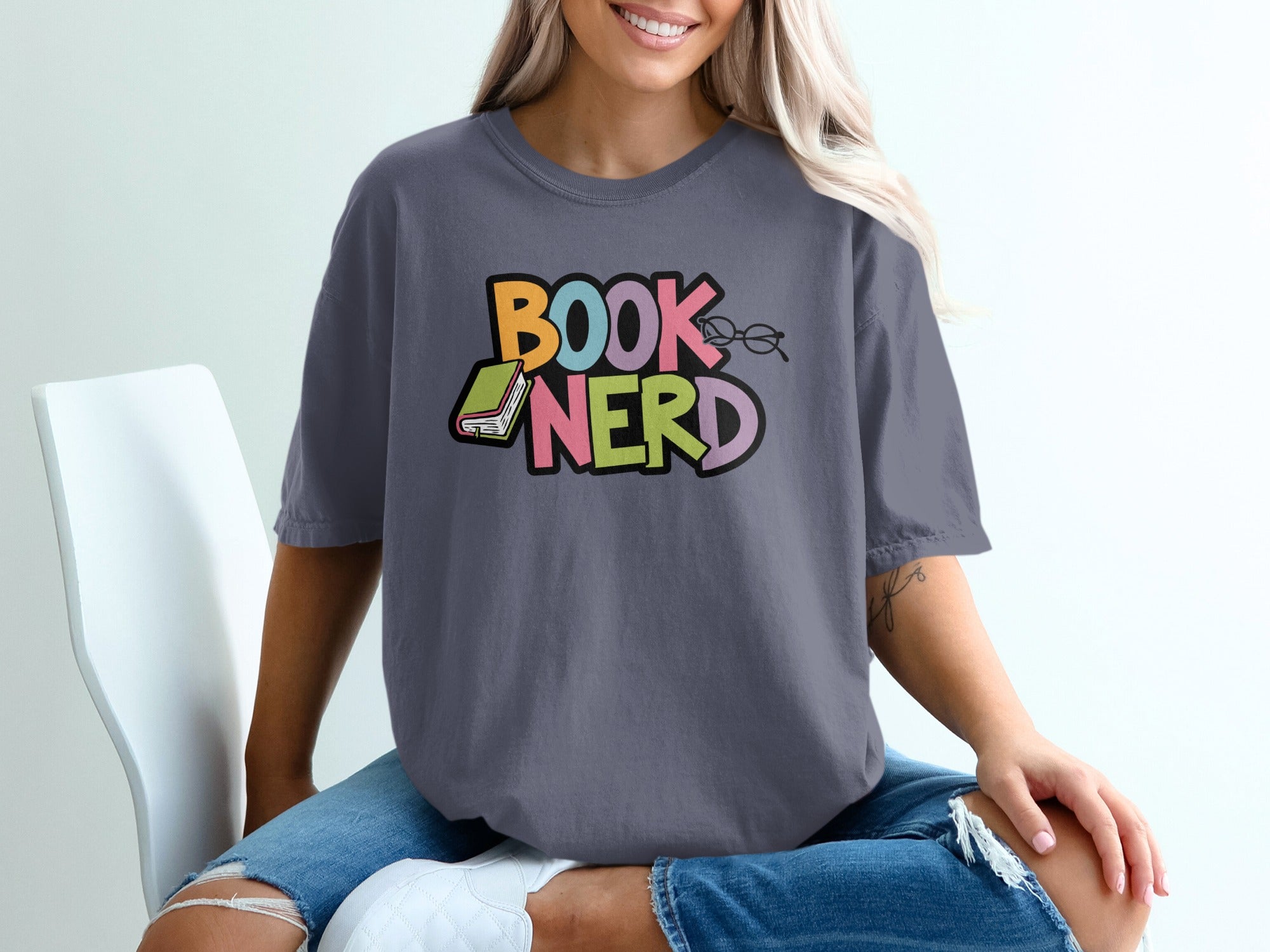 Gray t-shirt with colorful "BOOK NERD" text, a book, and glasses.