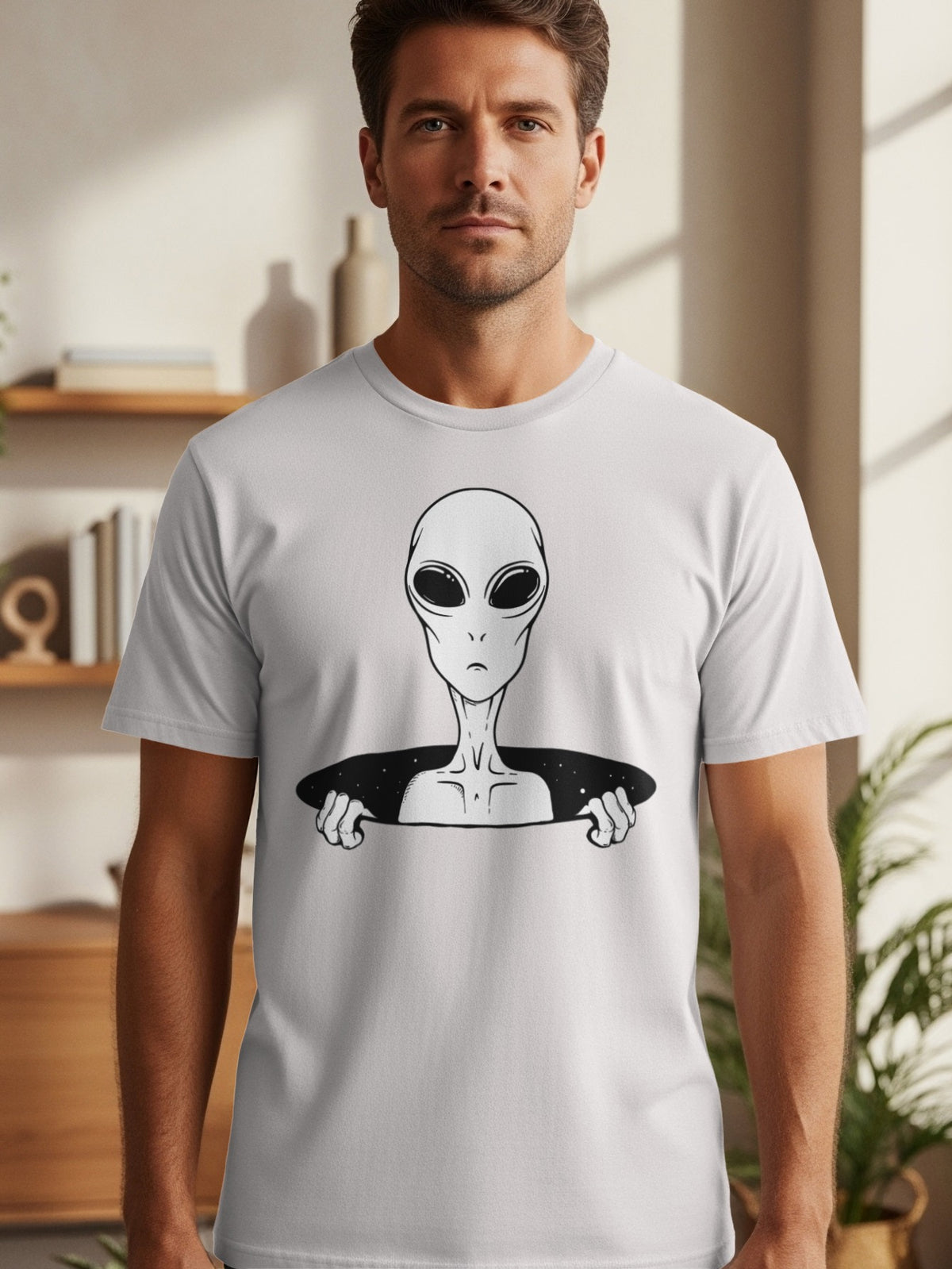 Man wearing a grey t-shirt with a black and white alien design bursting through.