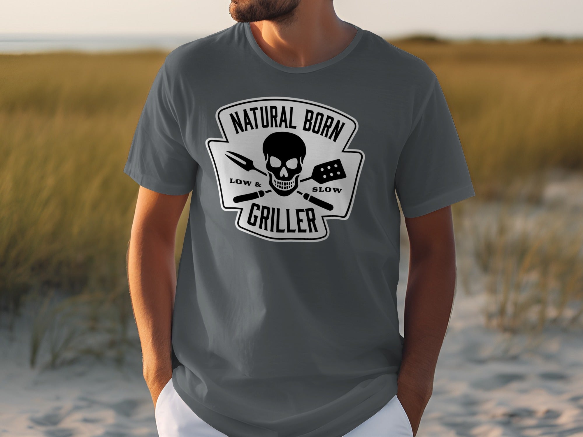 T-shirt with black graphic of skull with grilling tools and text "Natural Born Griller".
