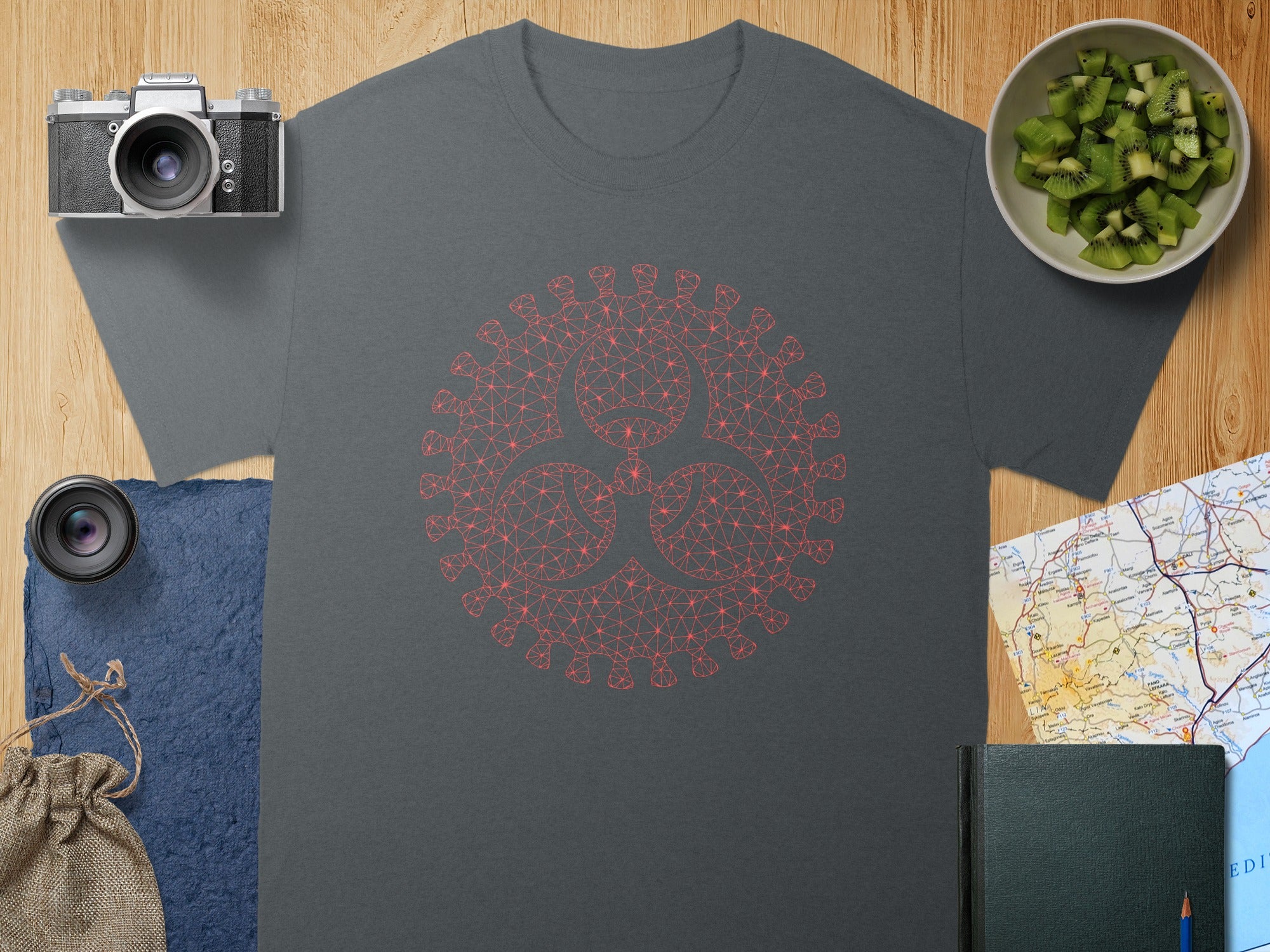 Gray t-shirt with a geometric red virus symbol and assorted props.