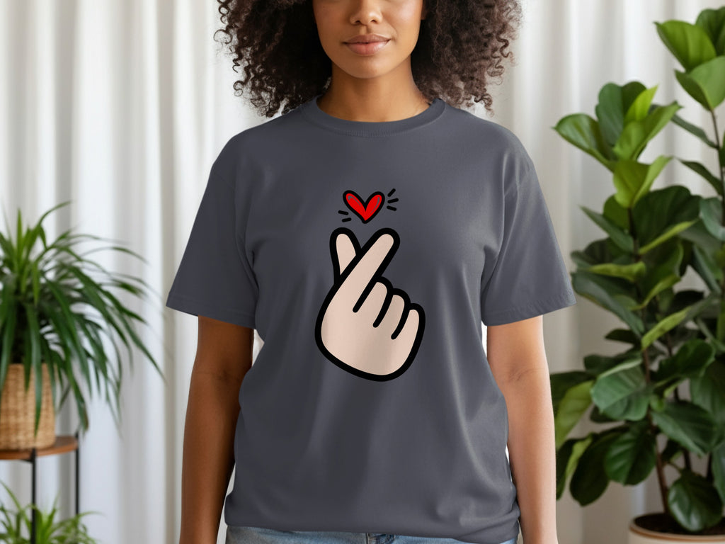Woman wearing a grey t-shirt with a hand gesture and a red heart graphic.