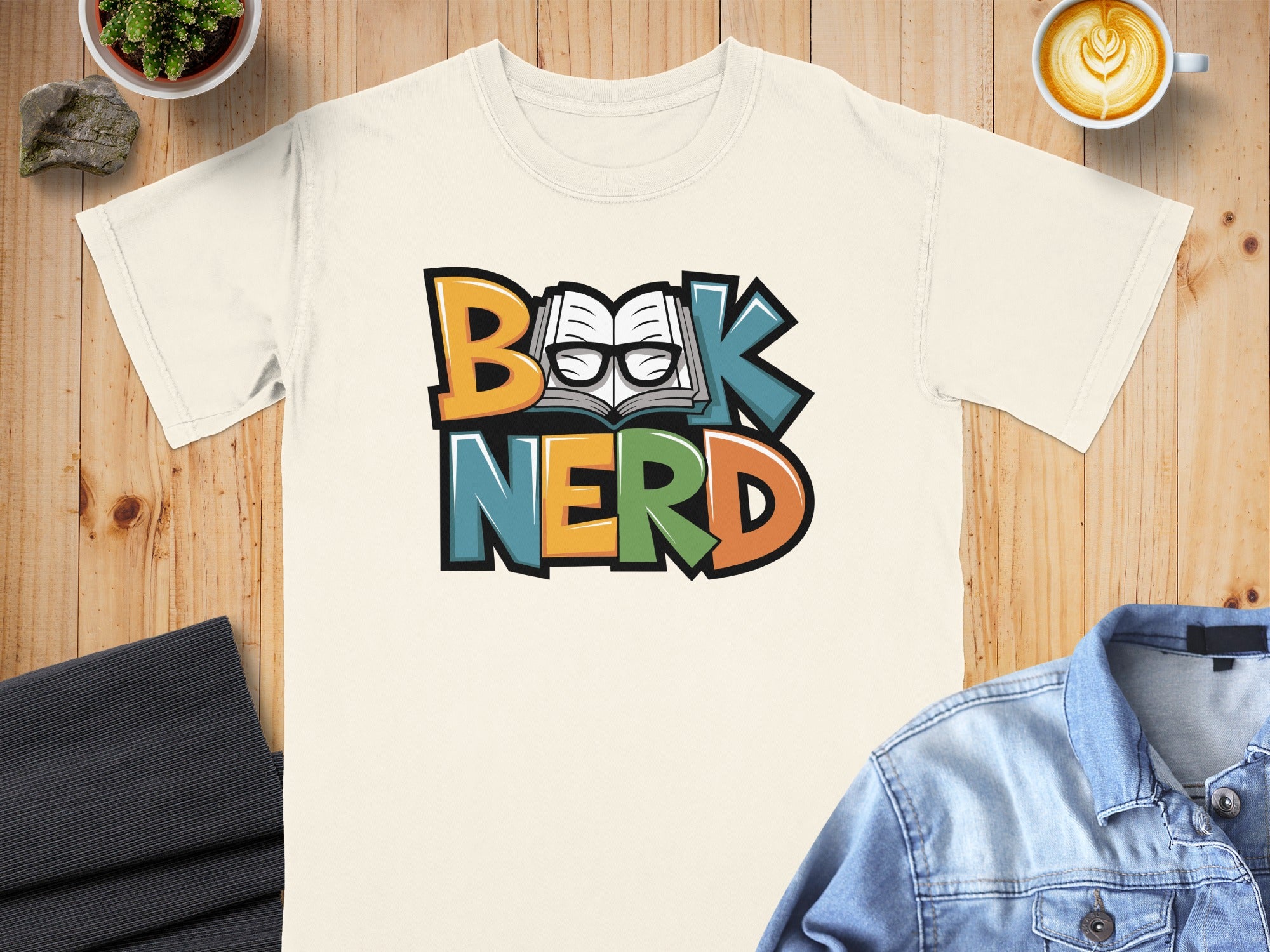 Cream t-shirt with colorful "Book Nerd" text and glasses over an open book.