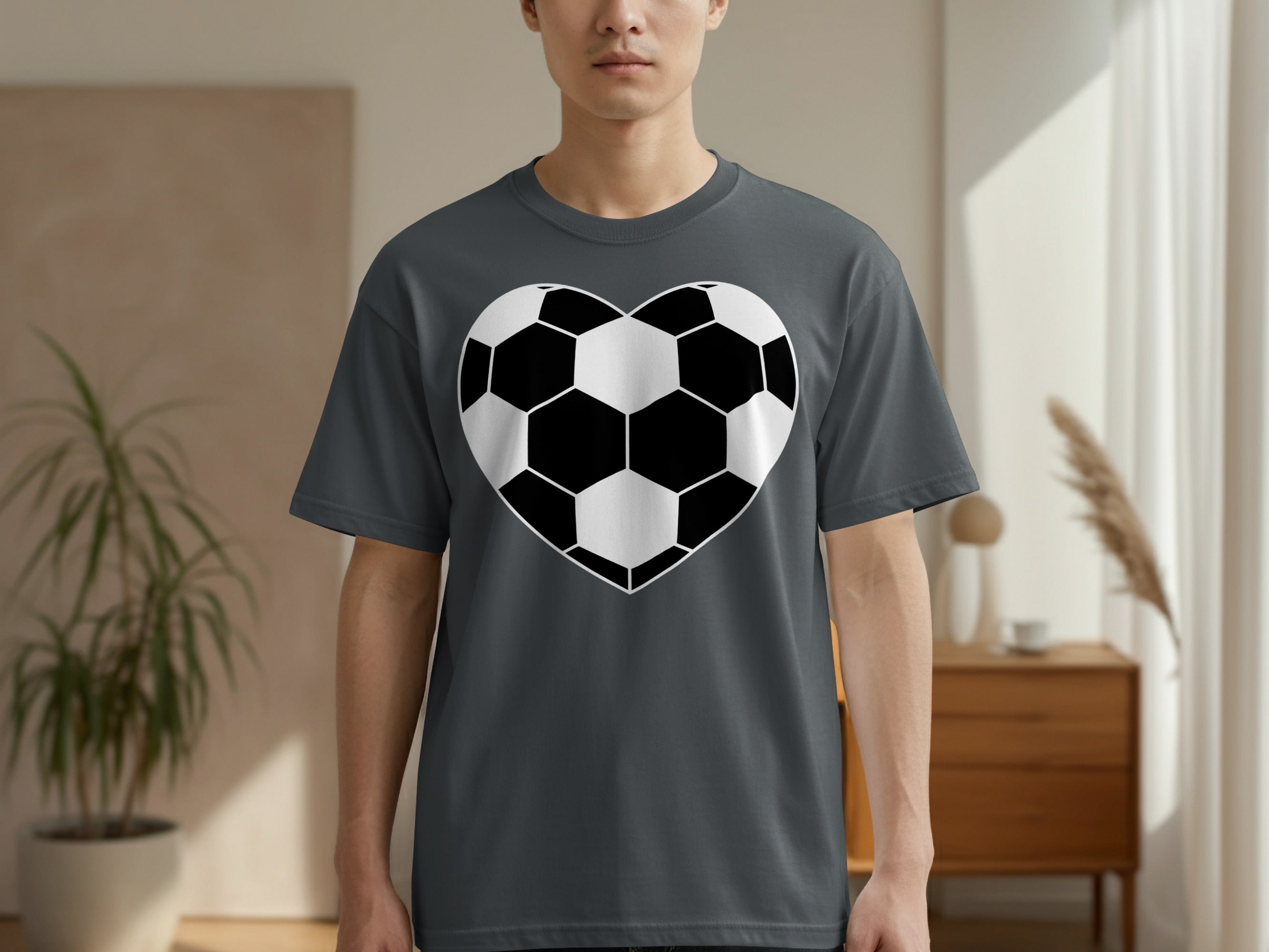 Gray t-shirt on a man featuring a black and white heart-shaped soccer ball design.