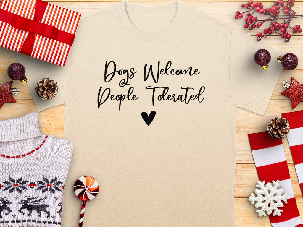 Beige t-shirt with black text "Dogs Welcome People Tolerated" and a heart.