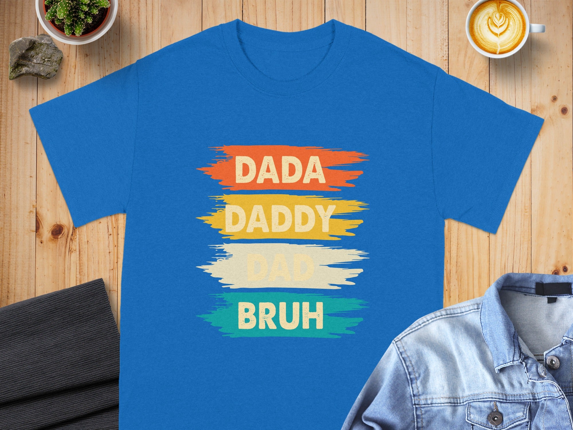 Blue t-shirt with "DADA DADDY DADD BRUH" text in colorful brush strokes.