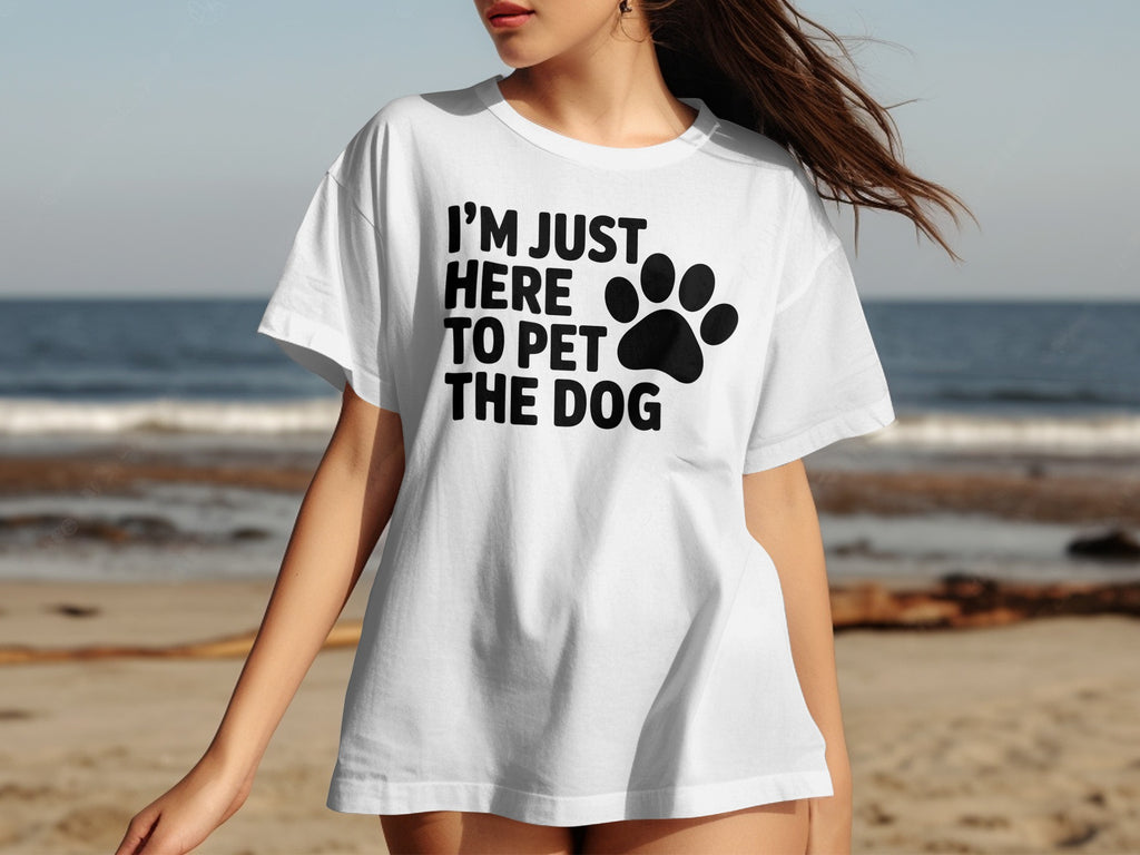White t-shirt with black text "I'M JUST HERE TO PET THE DOG" and paw print.