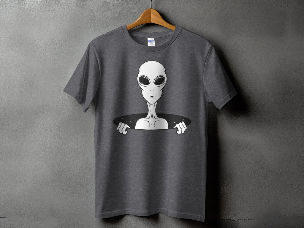 Gray t-shirt with a white alien emerging from a black oval space.