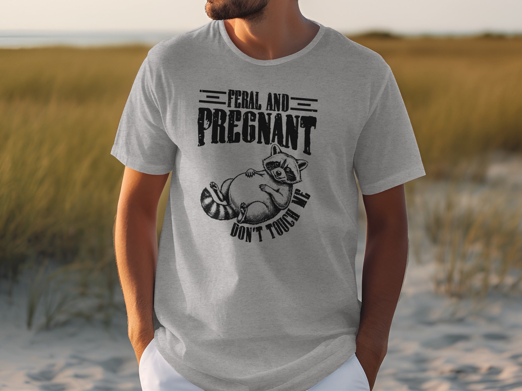 Grey t-shirt with raccoon graphic that reads "Feral and Pregnant Don't Touch Me."