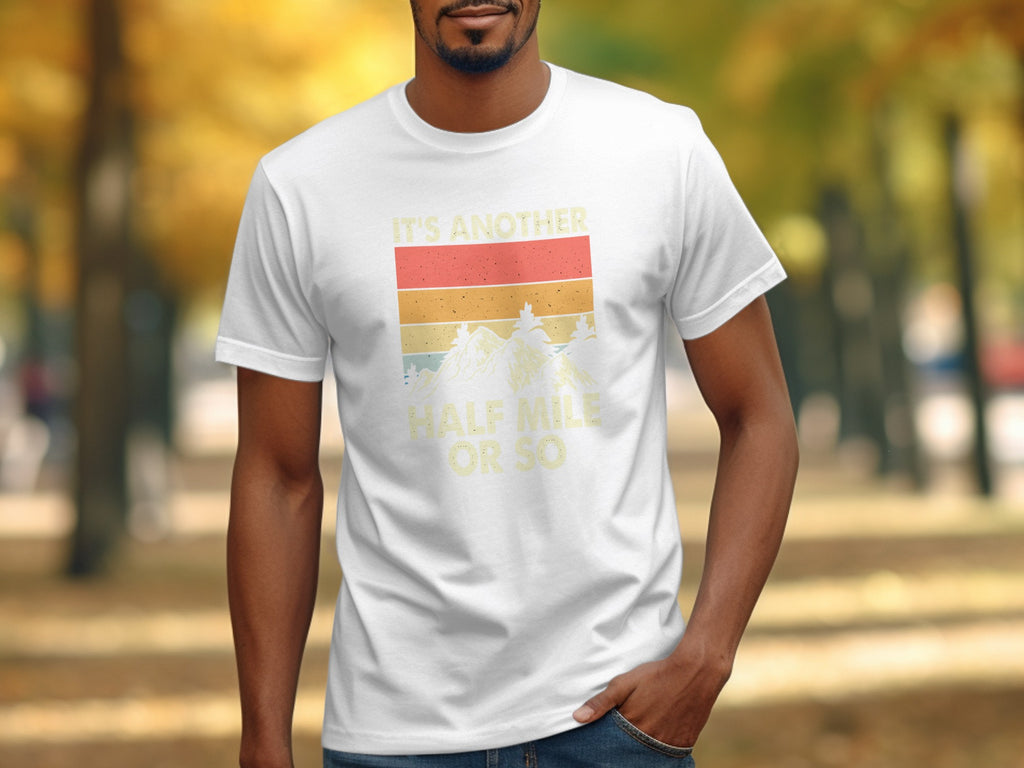 White t-shirt with retro sunset graphic and text "IT'S ANOTHER HALF MILE OR SO."