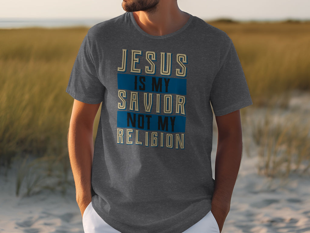 Dark grey t-shirt with text "JESUS IS MY SAVIOR NOT MY RELIGION"