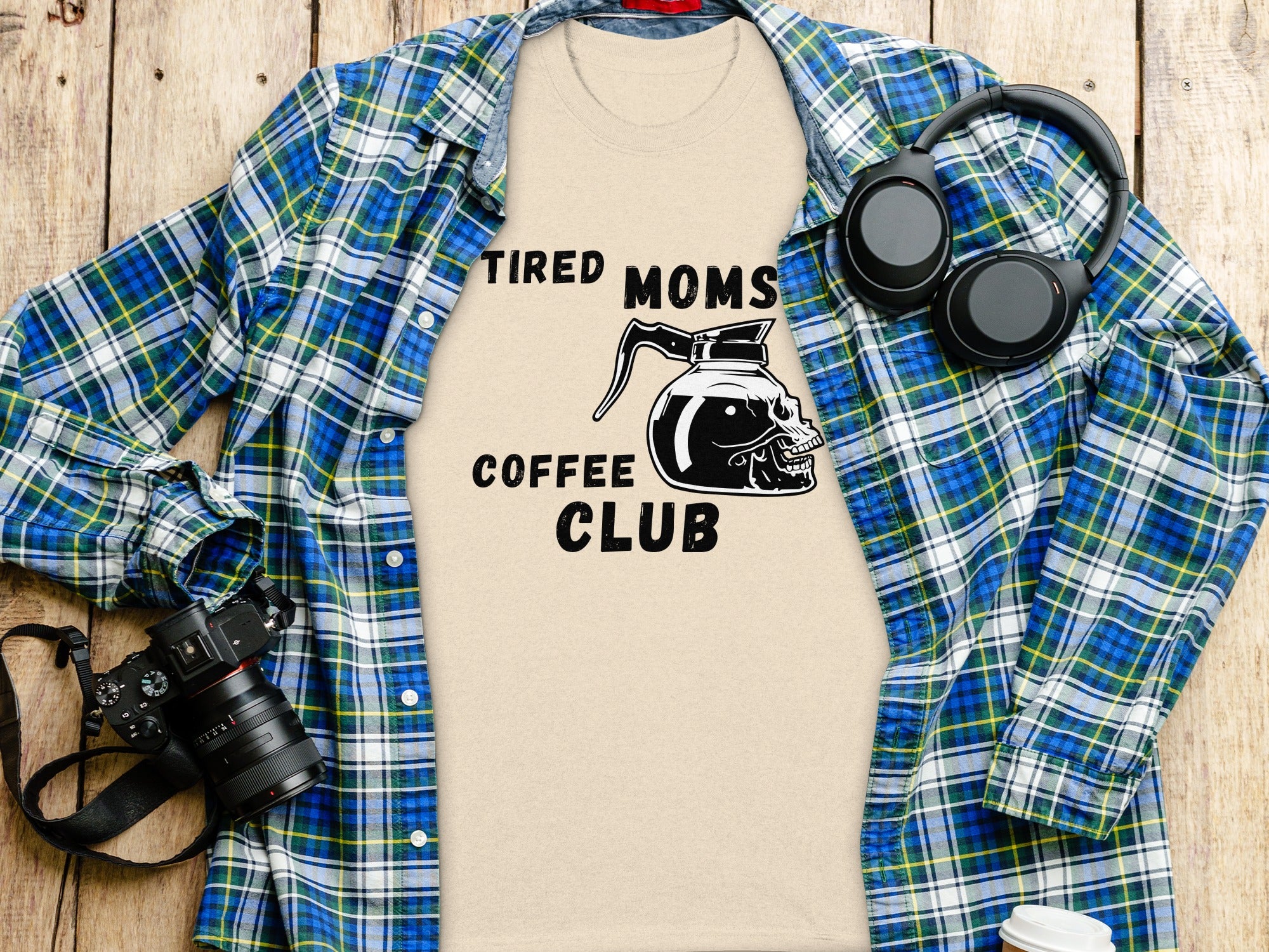 Tired Moms Coffee Club graphic on a light tan t-shirt with headphones and camera.