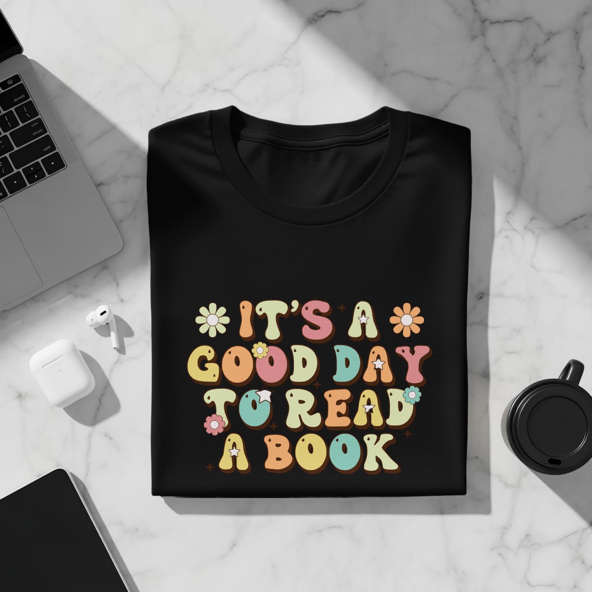Black t-shirt with "IT'S A GOOD DAY TO READ A BOOK" text and floral accents.