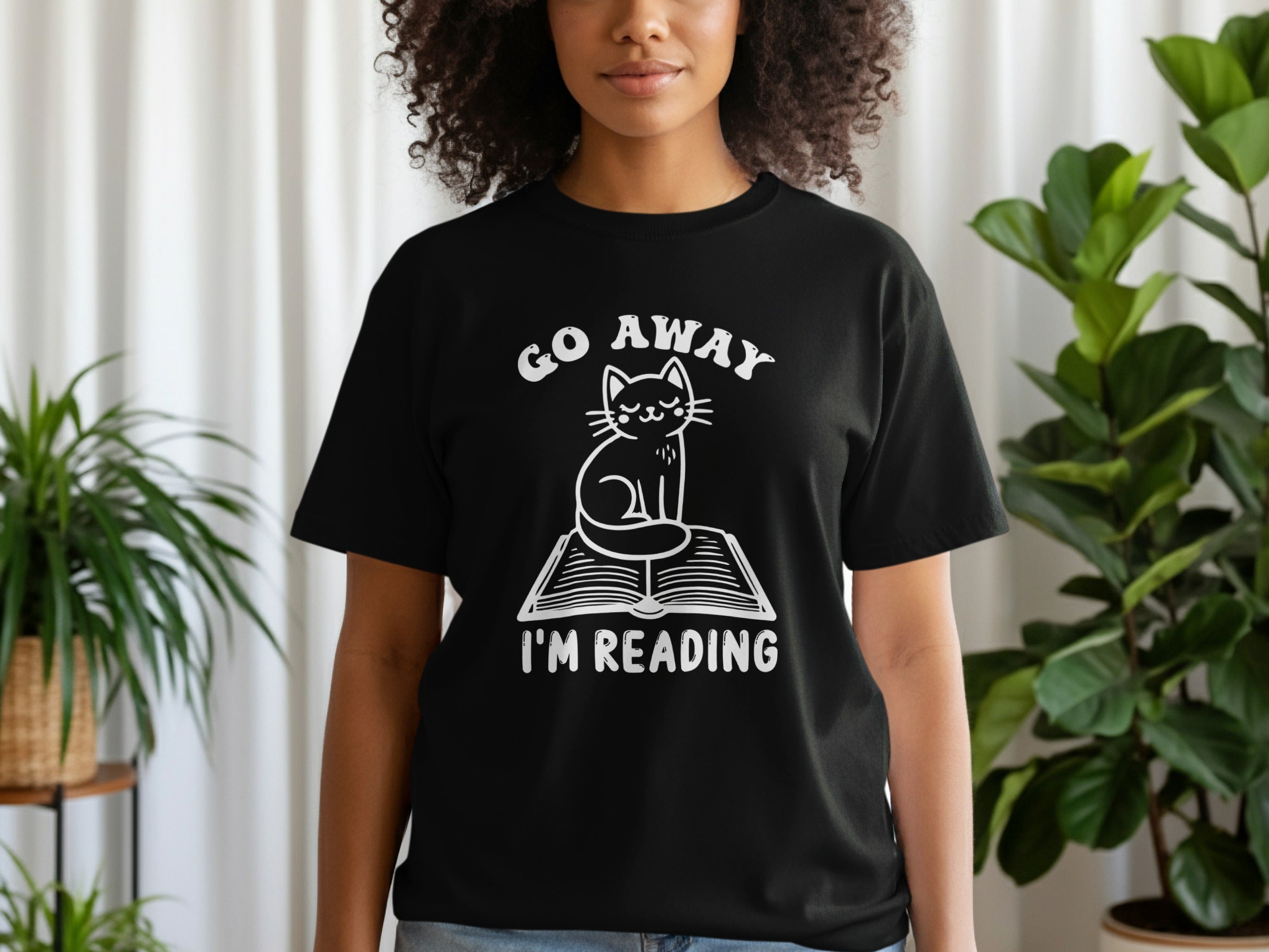 Black t-shirt with white text and cat graphic reading "GO AWAY I'M READING".