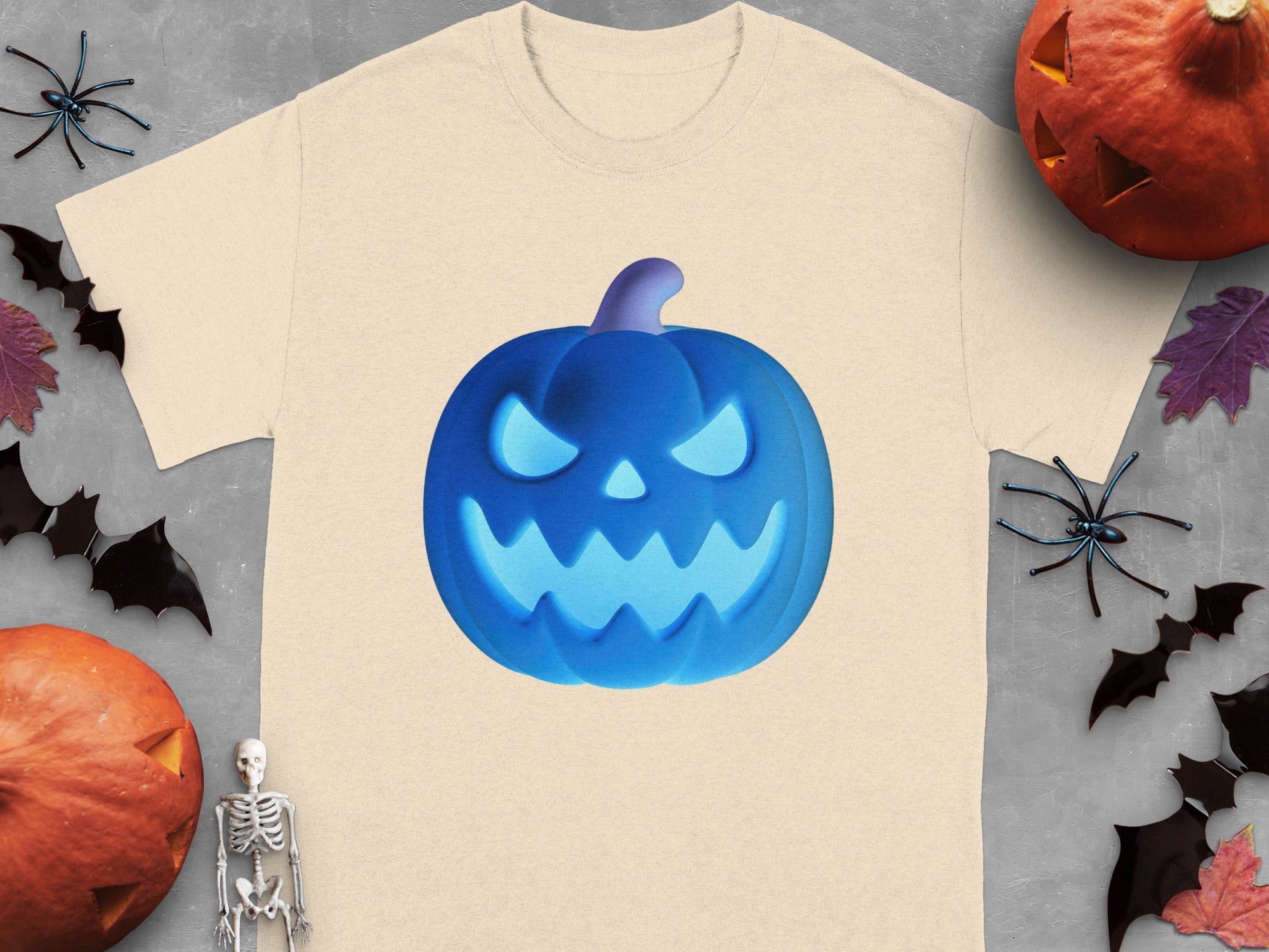 Tan t-shirt with a glowing blue jack-o'-lantern graphic, surrounded by Halloween decorations.