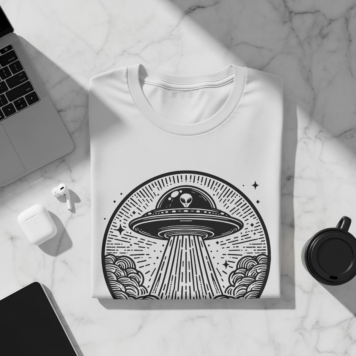 White t-shirt with black alien and UFO graphic in a circular design.