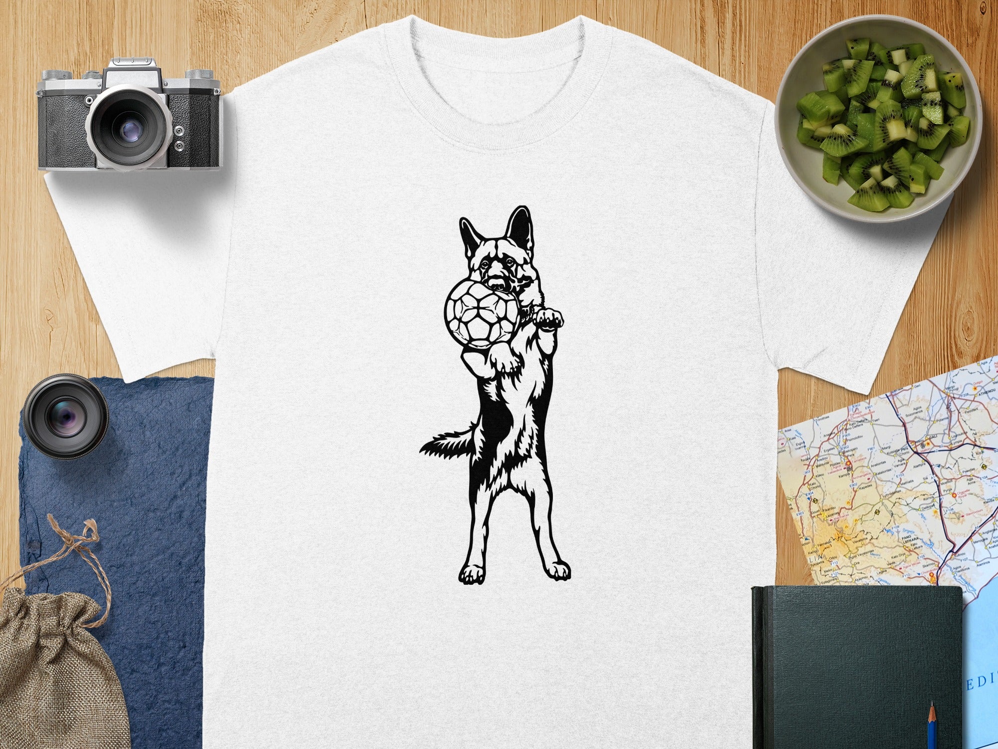 German Shepherd with a soccer ball graphic design on a white t-shirt.