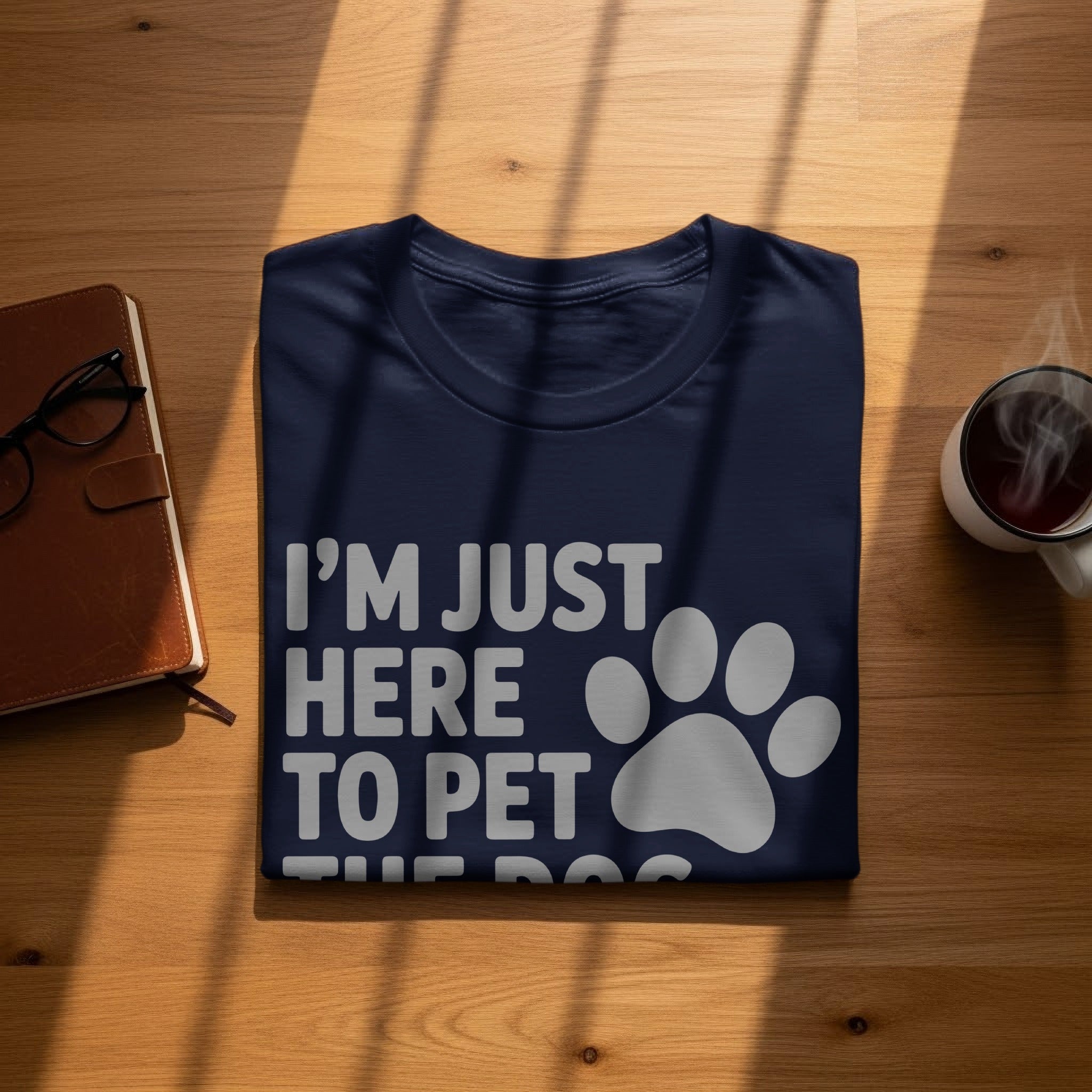 Navy t-shirt with white text "I'M JUST HERE TO PET THE DOG" and paw print.