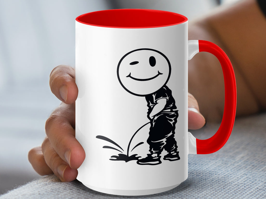 White mug with red interior and handle, featuring a black silhouette of a winking smiley face urinating.