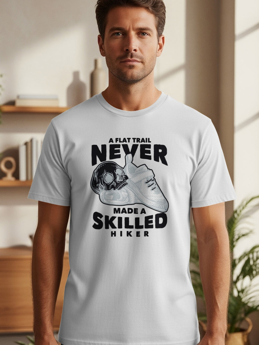White t-shirt with graphic: "A flat trail never made a skilled hiker" and skull.