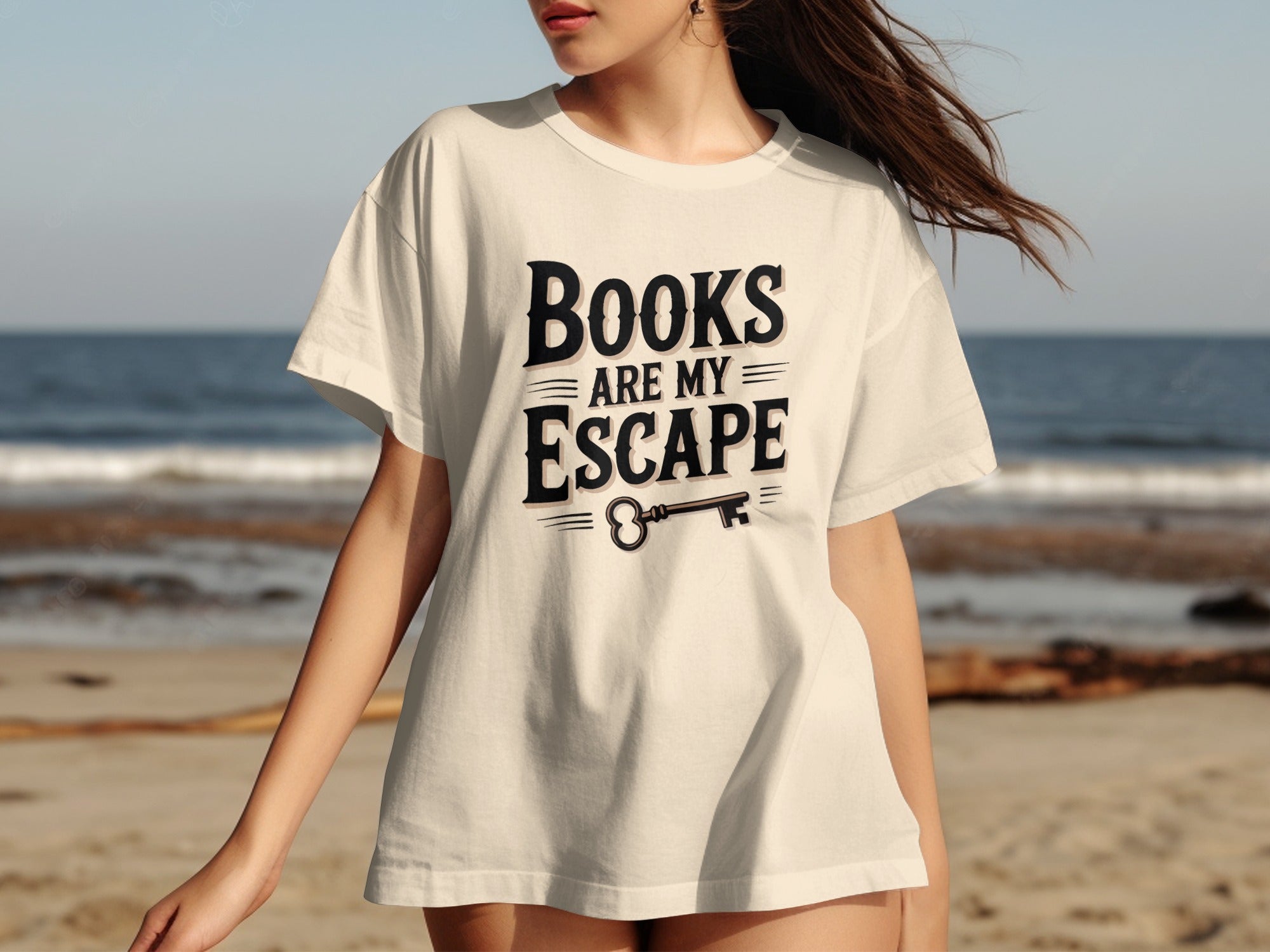 Cream t-shirt with "Books Are My Escape" text and key graphic on a beach.