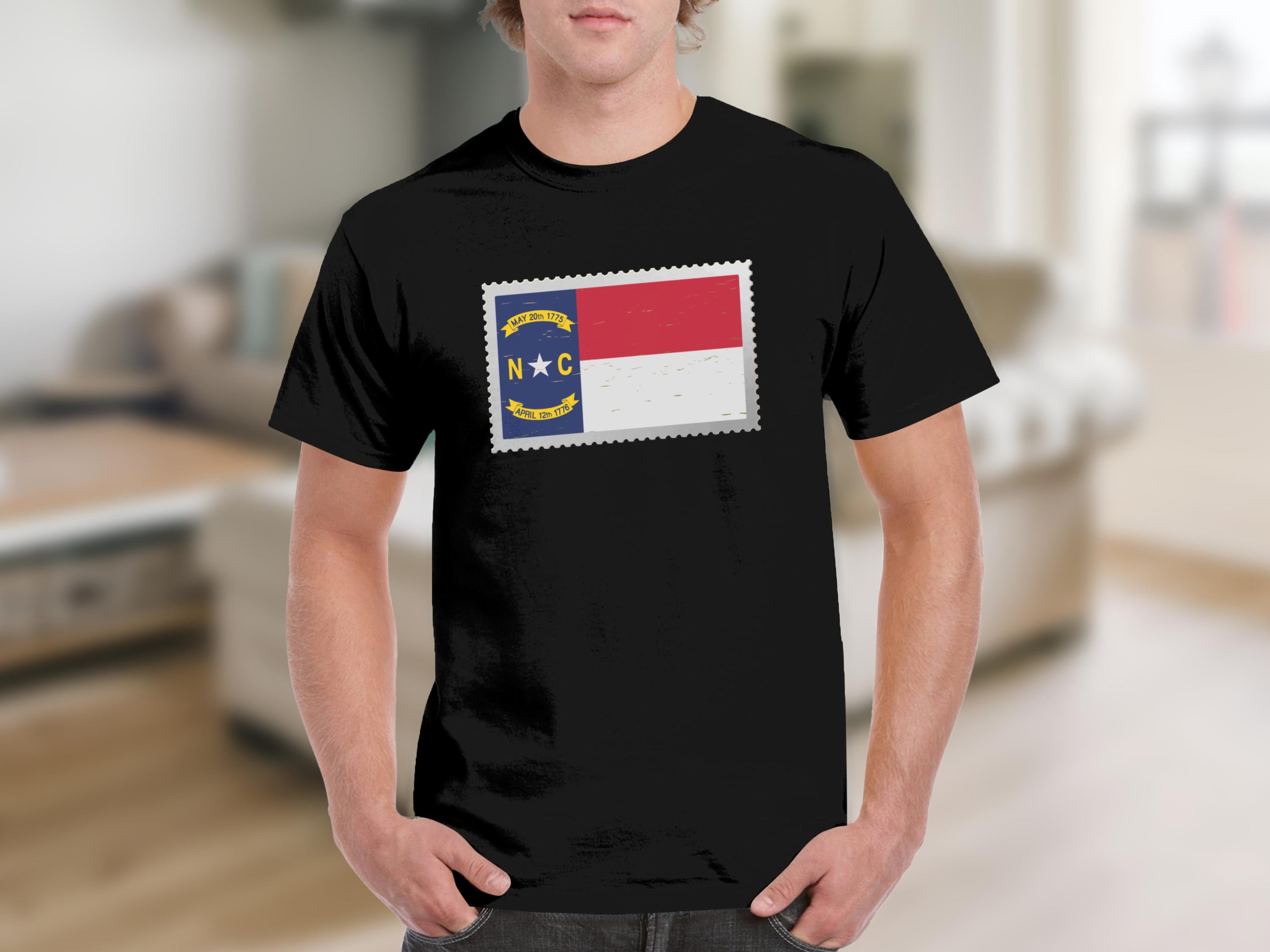 Black t-shirt with a North Carolina flag design inside a stamp outline.