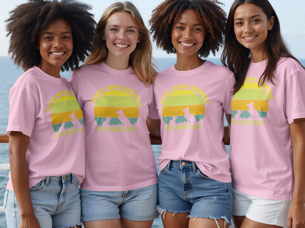 Four women smile wearing pink t-shirts with a sunset graphic and text.