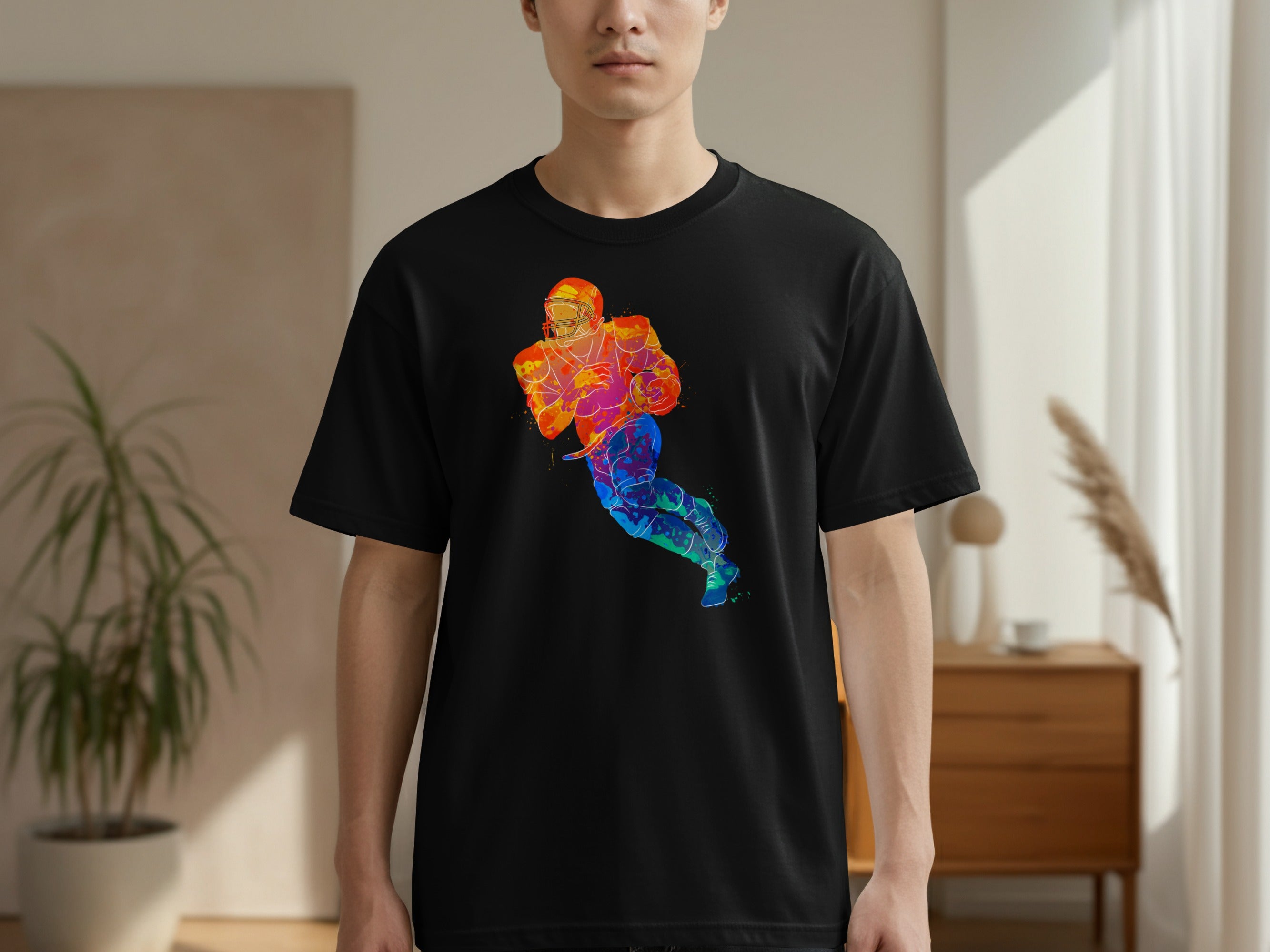 Black t-shirt with a watercolor-style football player graphic in vibrant colors.