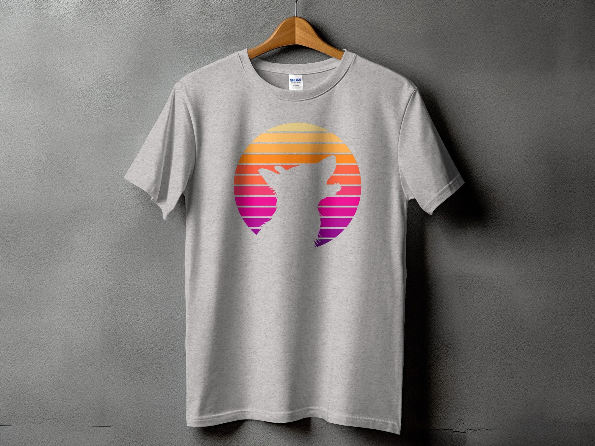 Grey t-shirt with a silhouette of a dog's head inside a vibrant sunset circle.