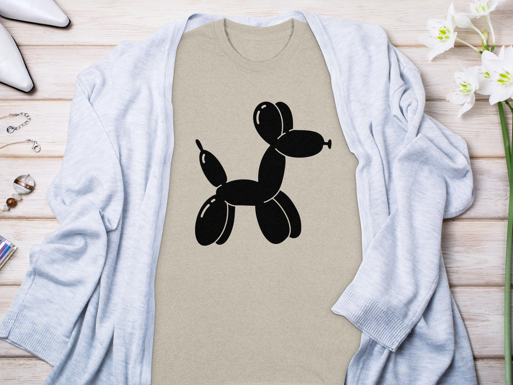 Tan t-shirt with black balloon dog graphic, draped with a light blue cardigan.