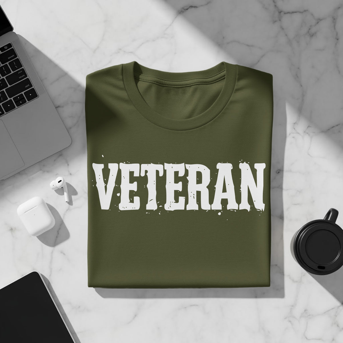 Green t-shirt with white distressed "VETERAN" text and subtle splatters.