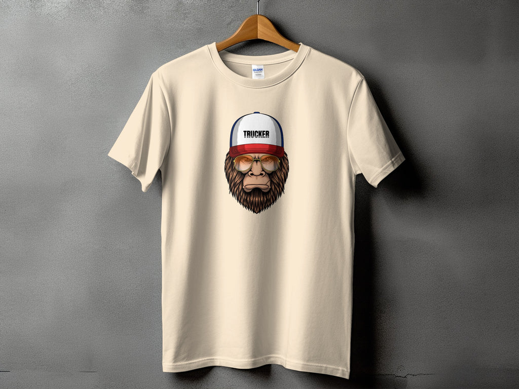 Beige t-shirt with Bigfoot wearing a trucker hat and sunglasses graphic.