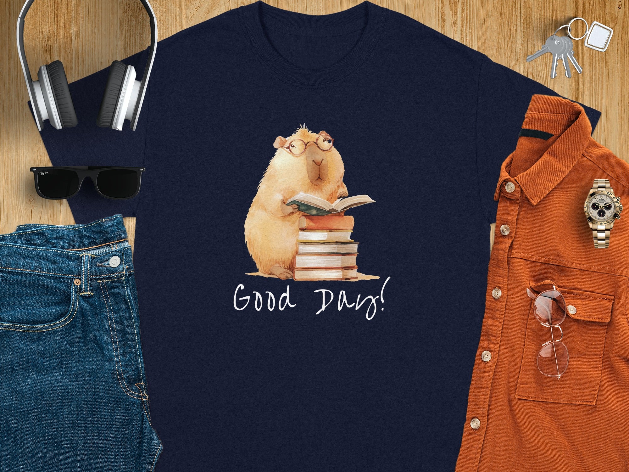 Dark blue t-shirt with watercolor capybara reading a book, "Good Day!" text.