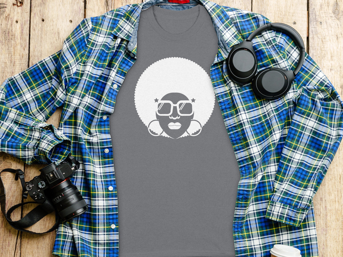 Grey t-shirt with white afro silhouette graphic, layered under a blue and green plaid shirt.