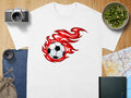 White t-shirt with a soccer ball on fire graphic on the chest.