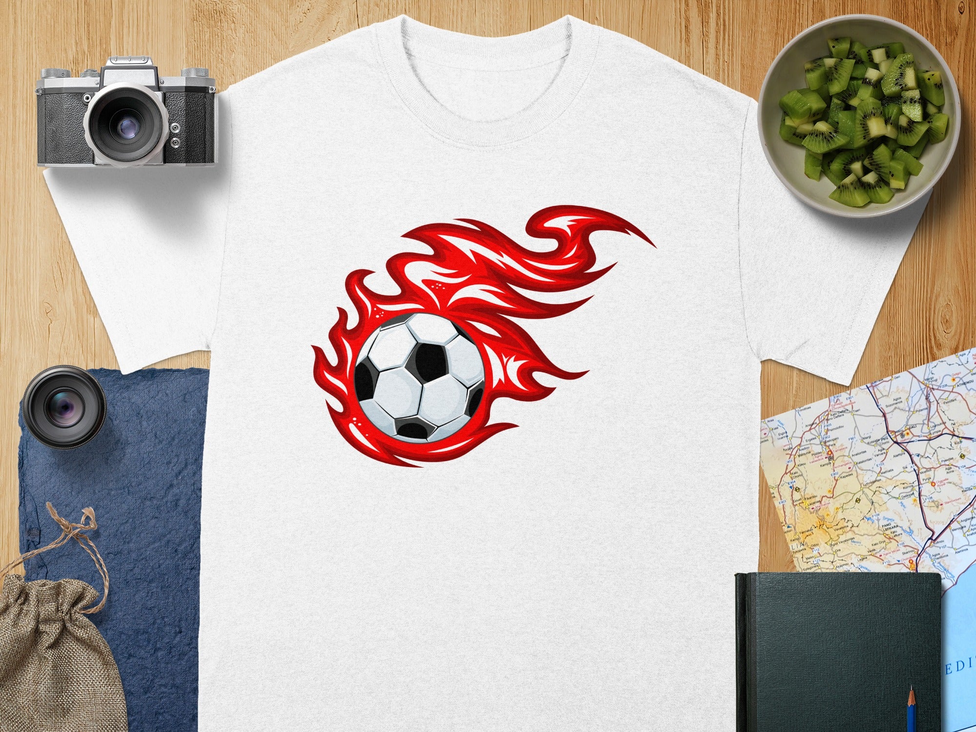 White t-shirt with a soccer ball on fire graphic on the chest.