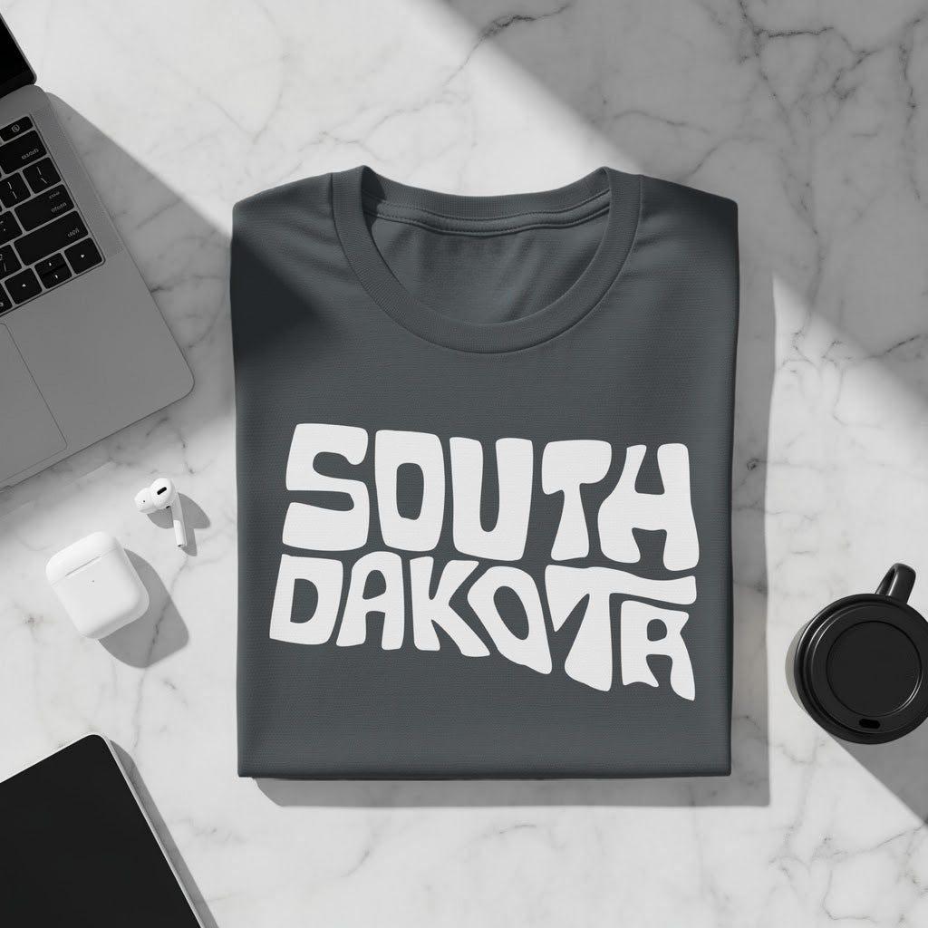 Dark gray t-shirt with white "SOUTH DAKOTA" text in a wavy font.