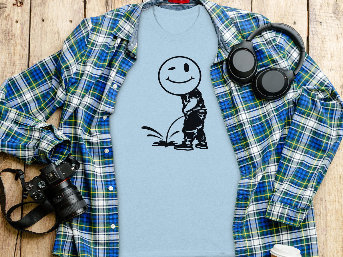 Light blue t-shirt with a winking smiley face character urinating.