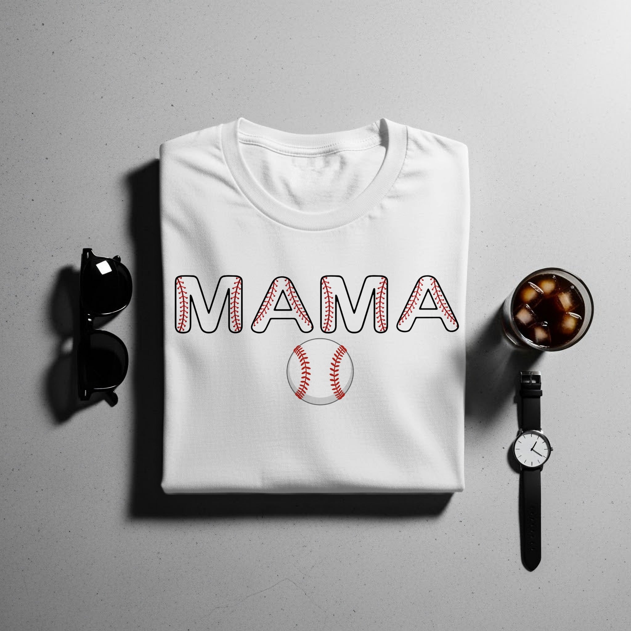 White t-shirt with "MAMA" text and baseball graphic, with sunglasses, drink, and watch.