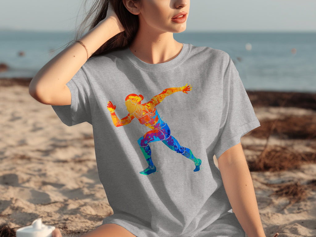 Grey t-shirt with a colorful running figure graphic on a beach.